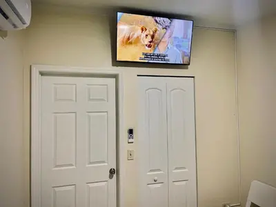 a flat screen tv on a wall above a door at Private Room near Miami Airport - Free parking - 02 in Miami