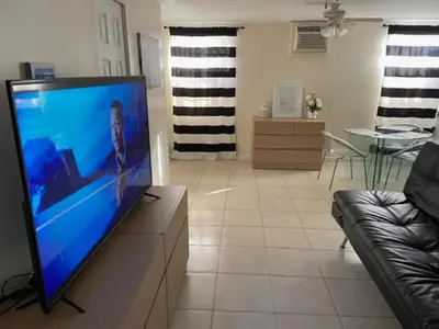 a living room with a flat screen tv on a dresser at Private Room near Miami Airport - Free parking - 02 in Miami