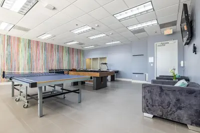 an office with a ping pong table and couches at Brickell Apt with Bay Views, Pool, Free Parking in Miami