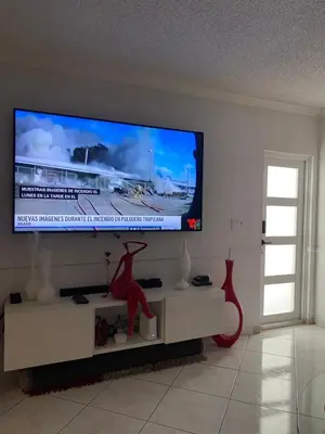 a living room with a flat screen tv on a wall at Beautiful House 7 min from Miami Airport w FREE parking in Miami