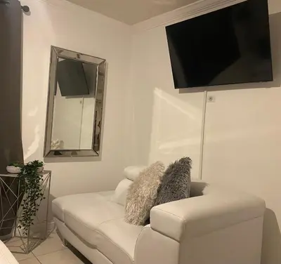 a living room with a white couch and a flat screen tv at Beautiful House 7 min from Miami Airport w FREE parking in Miami