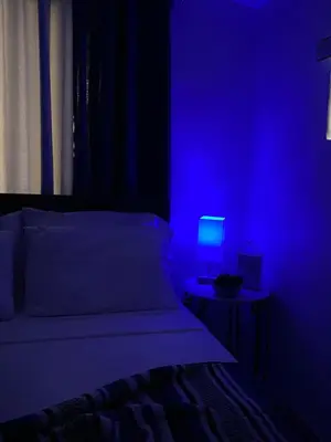 a blue room with a bed and a table with a lamp at Beautiful House 7 min from Miami Airport w FREE parking in Miami
