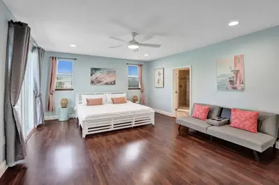 a bedroom with a white bed and a couch at Water Front Home with Boat Dock Hot Tub Roof Top Fire Pit in Fort Lauderdale