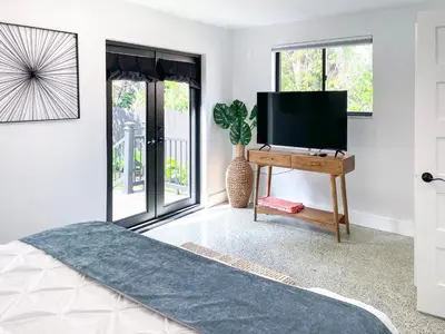 a bedroom with a television and a table with a tv at Private King Suite in Miami in Miami