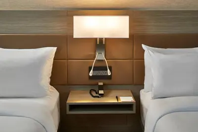 a hotel room with two beds and a lamp on a night stand at AC Hotel Miami Wynwood in Miami