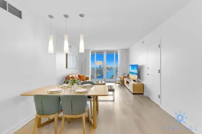 a dining room and living room with a table and chairs at MODERNResortBALCONY in Hallandale Beach