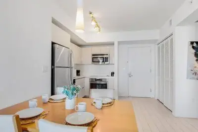 a kitchen and dining room with a table and chairs at Pool - Apartment with Balcony - Gym - Near Beach in Hallandale Beach