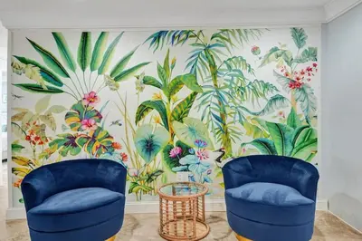 a room with two blue chairs in front of a tropical mural at Hot Tub! Roof Top! Firepit! Boat Dock! in Fort Lauderdale