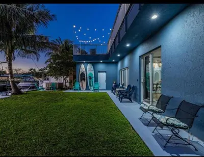 a house with a yard with chairs and a lawn at Hot Tub! Roof Top! Firepit! Boat Dock! in Fort Lauderdale