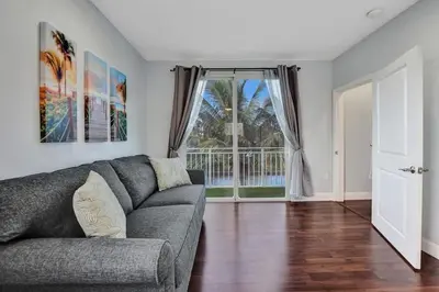 a living room with a couch and a large window at Hot Tub! Roof Top! Firepit! Boat Dock! in Fort Lauderdale
