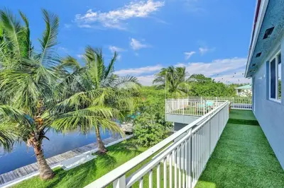 a balcony with palm trees and the water at Hot Tub! Roof Top! Firepit! Boat Dock! in Fort Lauderdale