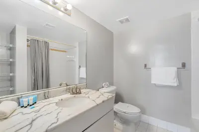 a white bathroom with a sink and a toilet at Fantastic 2BR Condo on 31st Floor Free Parking in Miami