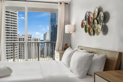 a bedroom with a white bed and a large window at Fantastic 2BR Condo on 31st Floor Free Parking in Miami