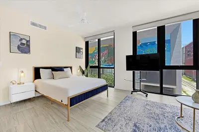 a bedroom with a bed and a flat screen tv at Devereaux Miami Luxury One-Bedroom and Studios in Miami