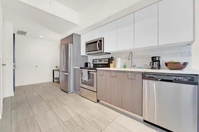 a kitchen with white cabinets and stainless steel appliances at Devereaux Miami Luxury One-Bedroom and Studios in Miami