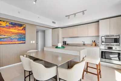 a kitchen with a table and chairs and a microwave at Ocean Views Perfect Location Resort Amenities in Hallandale Beach