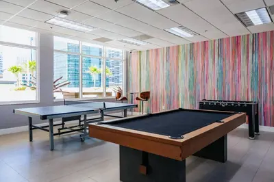 two ping pong tables in a room with colorful wallpaper at Brickell, Miami Home in the Sky! in Miami