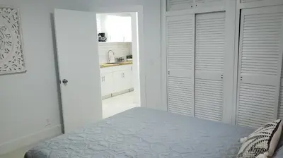 a white bedroom with a bed and a kitchen at Funston in Hollywood
