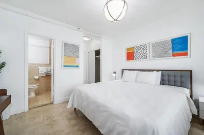 a white bedroom with a bed and a bathroom at Starlite Hotel in Miami Beach