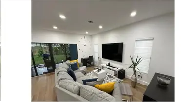 a living room with couches and a flat screen tv at Enjoy our brand new home close to Hollywood in Hallandale Beach! in Hallandale Beach