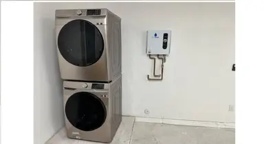 a microwave and a dryer next to a wall at Enjoy our brand new home close to Hollywood in Hallandale Beach! in Hallandale Beach