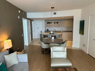 a living room with a table and chairs and a kitchen at Lyfe-1005 in Hollywood