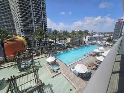 an overhead view of a swimming pool with umbrellas and palm trees at Lyfe-1005 in Hollywood