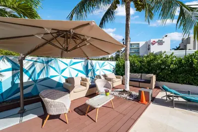 a patio with chairs and an umbrella on a deck at Deco Boutique Hotel in Fort Lauderdale