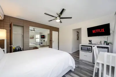 a bedroom with a white bed and a tv on a wall at Deco Boutique Hotel in Fort Lauderdale