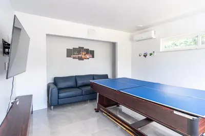 a living room with a ping pong table and a couch at Hollywood Paradise Luxury 4BR 3BA Home and Outdoor Fun with Heated Pool in Hollywood