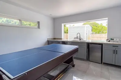 a kitchen with a table and a sink at Hollywood Paradise Luxury 4BR 3BA Home and Outdoor Fun with Heated Pool in Hollywood