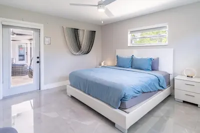 a white bedroom with a bed and a window at Hollywood Paradise Luxury 4BR 3BA Home and Outdoor Fun with Heated Pool in Hollywood