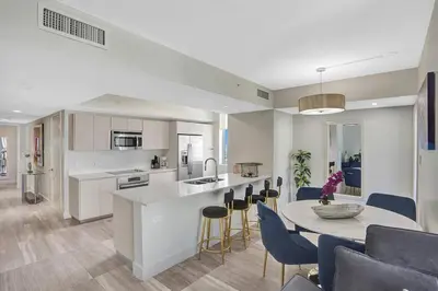 a kitchen and living room with a table and chairs at Luxury condo with ocean view 4Bedrooms 3Bathrooms in Hallandale Beach