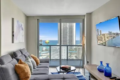 a living room with a couch and a large window at Luxury condo with ocean view 4Bedrooms 3Bathrooms in Hallandale Beach