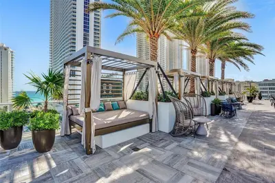 a swinging bed on a balcony with palm trees at Hyde Beach House - Stunning 2bd 2ba - Apt - Ocean & Intercostal views in Hollywood
