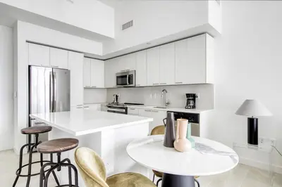 a kitchen with white cabinets and a table and chairs at Wynwood 1br w gym pool lounge nr Midtown MIA-35 in Miami