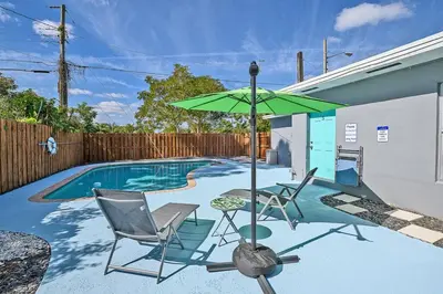 a patio with two chairs and an umbrella next to a pool at Enjoy and relax around Fort Lauderdale area!! in Fort Lauderdale