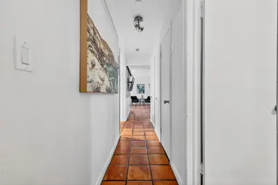a hallway with white walls and a tile floor at Sunny 2-Bedroom Miami Retreat with a Bright, Spacious Living Area & Relaxing Outdoor Seating in Fort Lauderdale