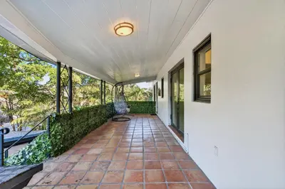 an empty porch of a house with a chair on it at Sunny 2-Bedroom Miami Retreat with a Bright, Spacious Living Area & Relaxing Outdoor Seating in Fort Lauderdale