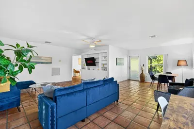 a living room with a blue couch and chairs at Sunny 2-Bedroom Miami Retreat with a Bright, Spacious Living Area & Relaxing Outdoor Seating in Fort Lauderdale