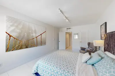 a bedroom with a bed and a painting on the wall at Decoplage Paradise - Main Home in Miami Beach
