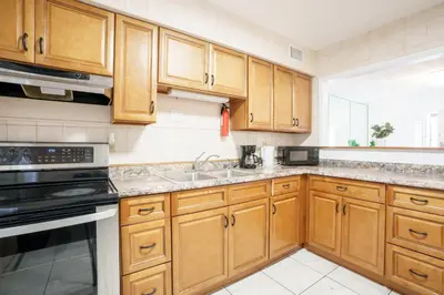 a kitchen with wooden cabinets and a sink at Modern 3-Bedroom in the Heart of Wynwood Art District in Miami