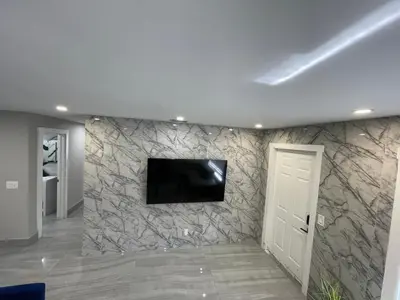a living room with a tv on a stone wall at Modern Villa with Pool Hollywood Hard Rock Casino in Fort Lauderdale