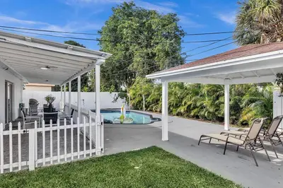 a backyard with a white fence and a swimming pool at Modern Villa with Pool Hollywood Hard Rock Casino in Fort Lauderdale
