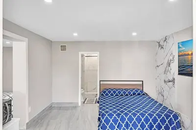 a bedroom with a blue bed in a white room at Modern Villa with Pool Hollywood Hard Rock Casino in Fort Lauderdale