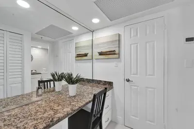 a white kitchen with a counter and a white door at Cozy Beachfront 2 BDR & 2 BA Miami Beach Condo in Miami Beach