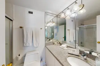 a bathroom with a toilet and a sink and a mirror at Decoplage Paradise - Unit B in Miami Beach