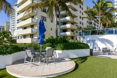 a patio with a table and chairs in front of a building at Decoplage Paradise - Unit B in Miami Beach
