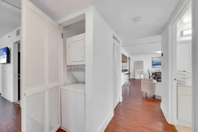 a white hallway with white cabinets and a living room at Ocean View Amazing Unit Brickell in Miami