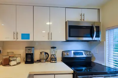 a kitchen with a stove and a microwave at Artful 3BR Oasis in Little Haiti, Miami in Miami